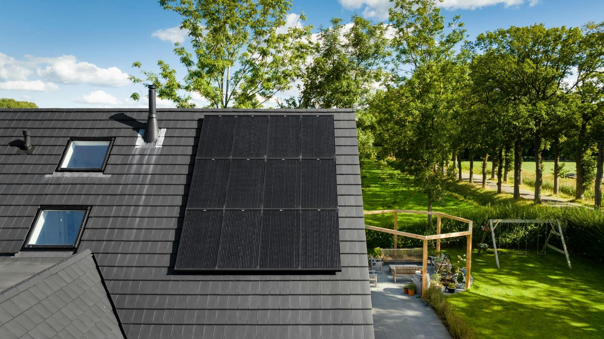 12 zwarte zonnepanelen op een dak van een vrijstaand huis