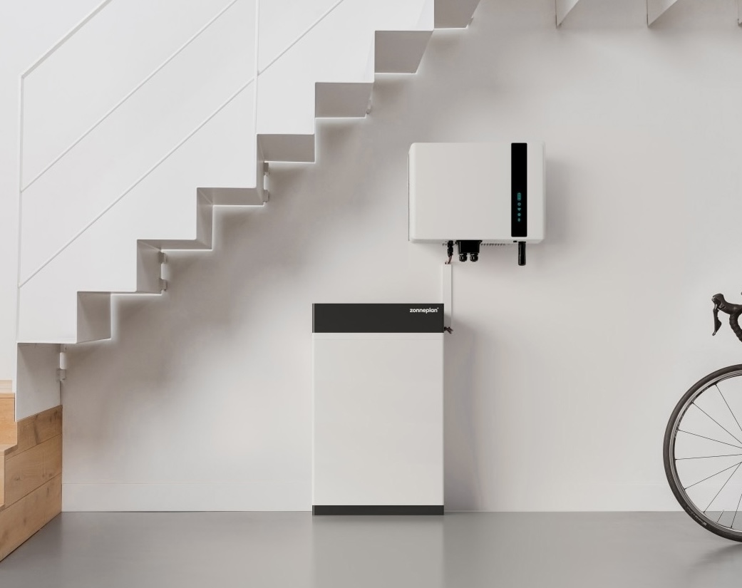 Een zonneplan thuisbatterij onder de trap met een fiets aan de rechterkant